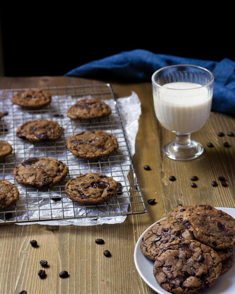 coffee chip cookies on a wire rack with a glass of milk