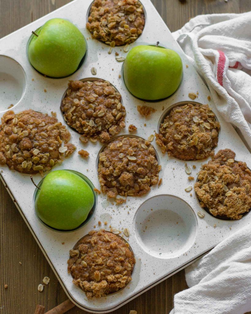 apple cider muffins in a muffin tin baking tray