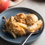 Warm and cozy dutch apple crisp with vanilla ice cream and cinnamon, ready for fall.