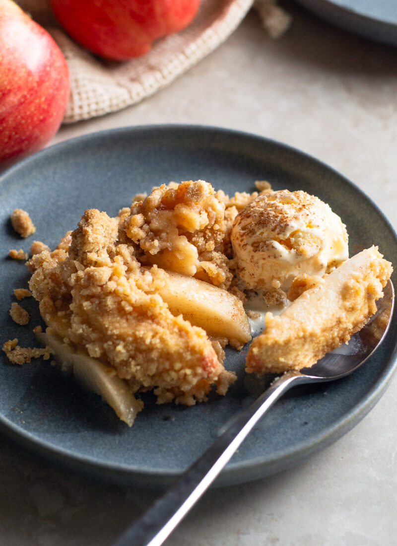 Warm and cozy dutch apple crisp with vanilla ice cream and cinnamon, ready for fall.