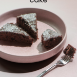 Three slices of chocolate snacking cake on a pink plate, topped with powdered sugar. Text reads "chocolate snacking cake" and "ficklebeabakehouse.com"
