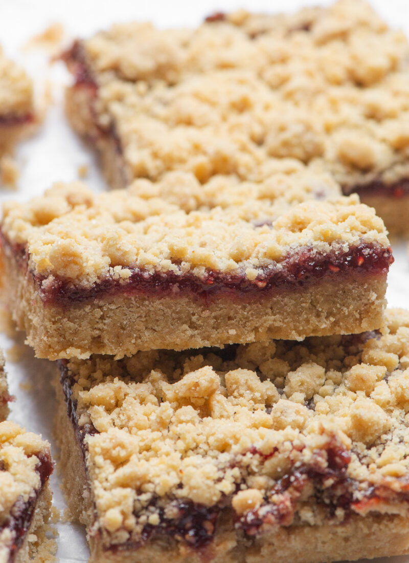 A PB&J crumble bar shown from the side to see the layer of raspberry jelly.