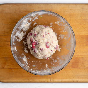 Shaggy scone dough has been patted into a ball and is waiting to be transferred to a lightly floured surface.