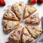 Freshly baked scones served with bright red fresh strawberries.