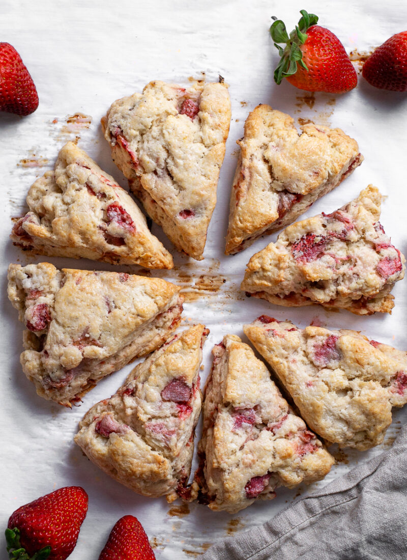 Freshly baked scones served with bright red fresh strawberries.