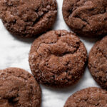 Perfectly round and slightly crinkled chocolate cookies, shimmering with a coat of granulated sugar.