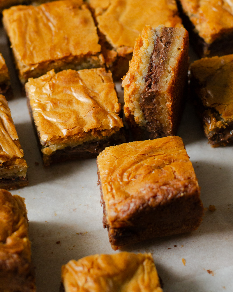 Malted Nutella blondies with crinkly tops and a gooey Nutella filling sandwiched in the middle.