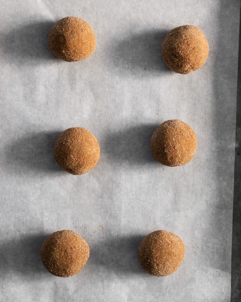 Pumpkin spice snickerdoodle dough rolled in cinnamon sugar and ready to be baked into perfectly cozy fall cookies!