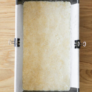 Shortbread dough, pressed evenly into a prepared bread pan with the back of a spoon.