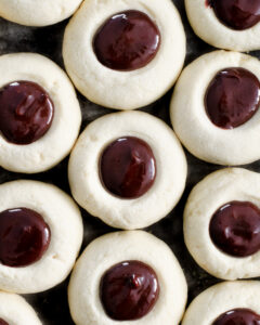 Filled chocolate ganache vanilla thumbprint cookies before the ganache has cooled and set.