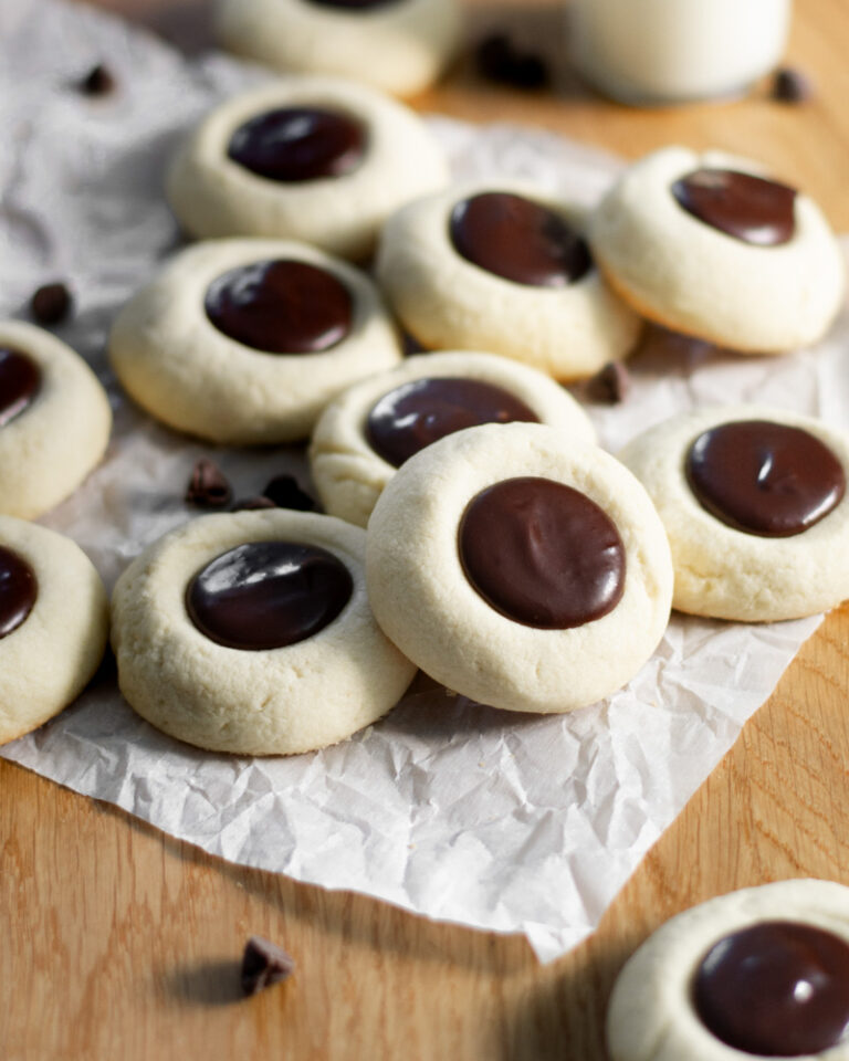 An easy recipe for delicious semi-sweet chocolate ganache vanilla thumbprint cookies that go great with a cold glass of milk!
