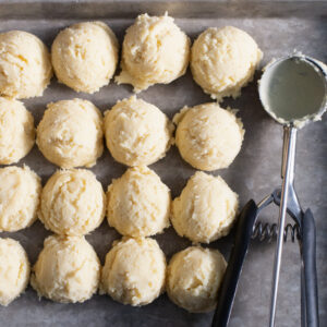 Scooped and portioned dough for vanilla thumbprint cookies.